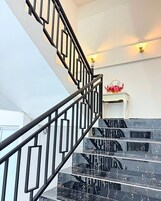 A staircase with black railings and marble steps.