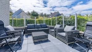 An outdoor patio area with a sofa set, chairs, and a table. - Charming Villa With Wood Stove Near the sea and Forest (De Koog)