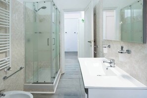 A modern bathroom with a glass-enclosed shower, a white sink, and a large mirror. - BuddyRent - Garden House - Vaticano - 3 ospiti (Roma)