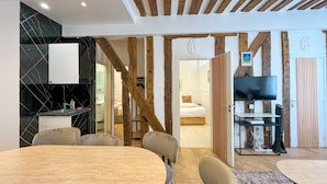 Ein modernes Hotelzimmer mit Essbereich, Fernseher und Holzboden.