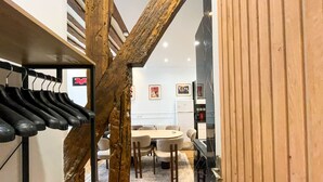 Eine Treppe mit Holzwangen führt zu einem Essbereich mit Tisch und Stühlen.