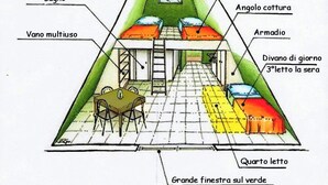 Quarto triangular com área de dormir em vários níveis, mesa de jantar e vista para a encosta verde.