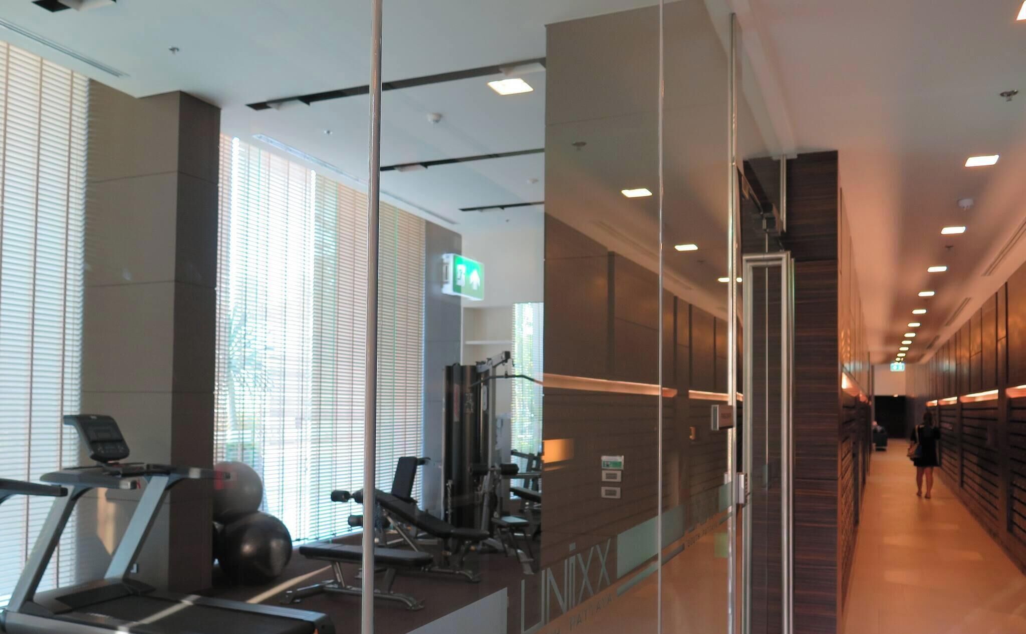 A gym area with exercise equipment, a treadmill, and a wall with a sign.