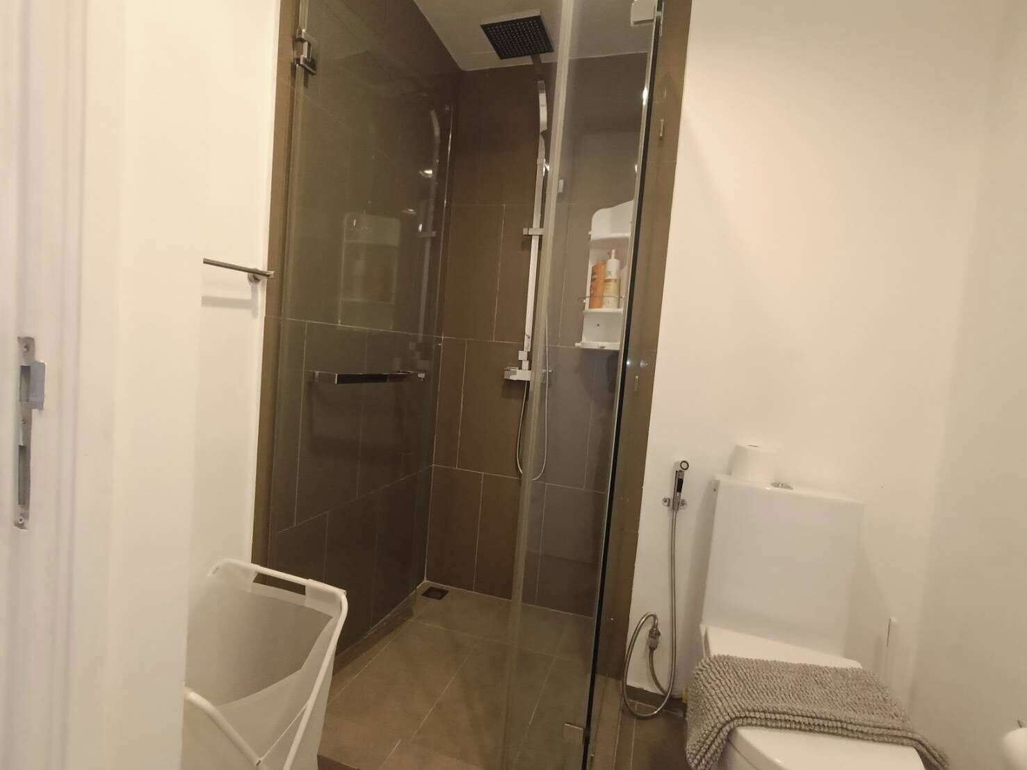 Ein modernes Badezimmer mit einer Duschkabine, einer Toilette und einem Waschbecken.