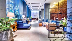 A modern hotel lobby with blue sofas, a reception desk, and a geometric wall structure. - The Unixx South Pattaya (Pattaya)