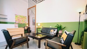 A modern lounge area with a sofa, two armchairs, and a coffee table. - Swing & Pillows @ 75 Chulia St, Georgetown Penang (George Town)