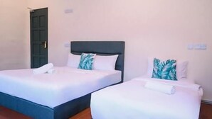 Two single beds with dark headboards, white bedding, and a green door in the background. - Swing & Pillows @ 75 Chulia St, Georgetown Penang (George Town)