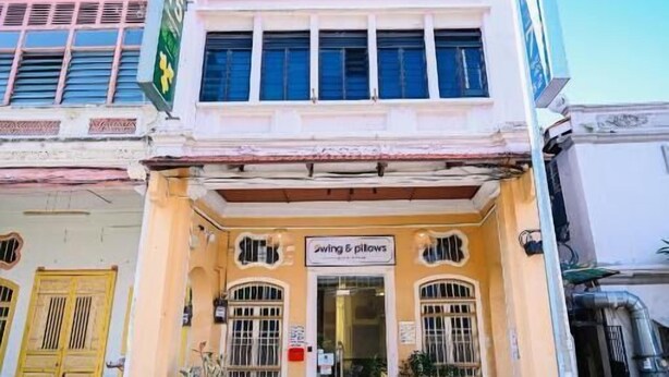 A two-story building with a sign for 'swimming & pillows' on the ground floor. - Swing & Pillows @ 75 Chulia St, Georgetown Penang (George Town)