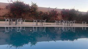 En pool med vita solstolar och en klar spegelbild.
