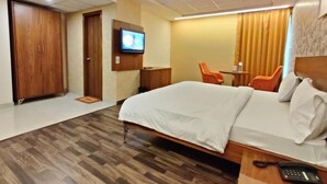 Une chambre d’hôtel équipée d’un lit, d’un bureau, d’une chaise, d’une télévision et d’une armoire.