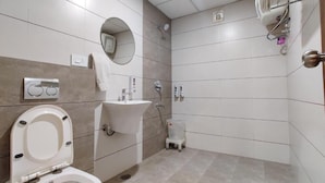 Une salle de bain moderne équipée de toilettes, d’un lavabo et d’une douche.