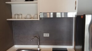 Una cucina moderna con lavello in acciaio inossidabile, piano cottura integrato e frigorifero.