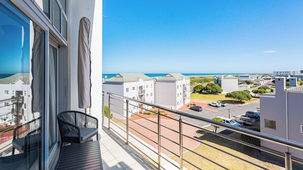 A balcony with a view of a residential area and the sea. -  Seaside Village C22 by CTHA (Cape Town)
