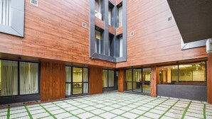 A hotel courtyard with a tiled floor and wooden walls. - Aroma Hotel Sultanpur (New Delhi)