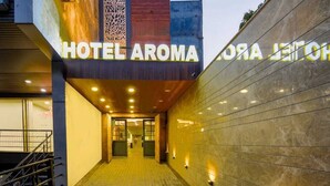 The entrance to Hotel Aroma with a modern design, featuring a prominent sign and a staircase leading inside. - Aroma Hotel Sultanpur (New Delhi)
