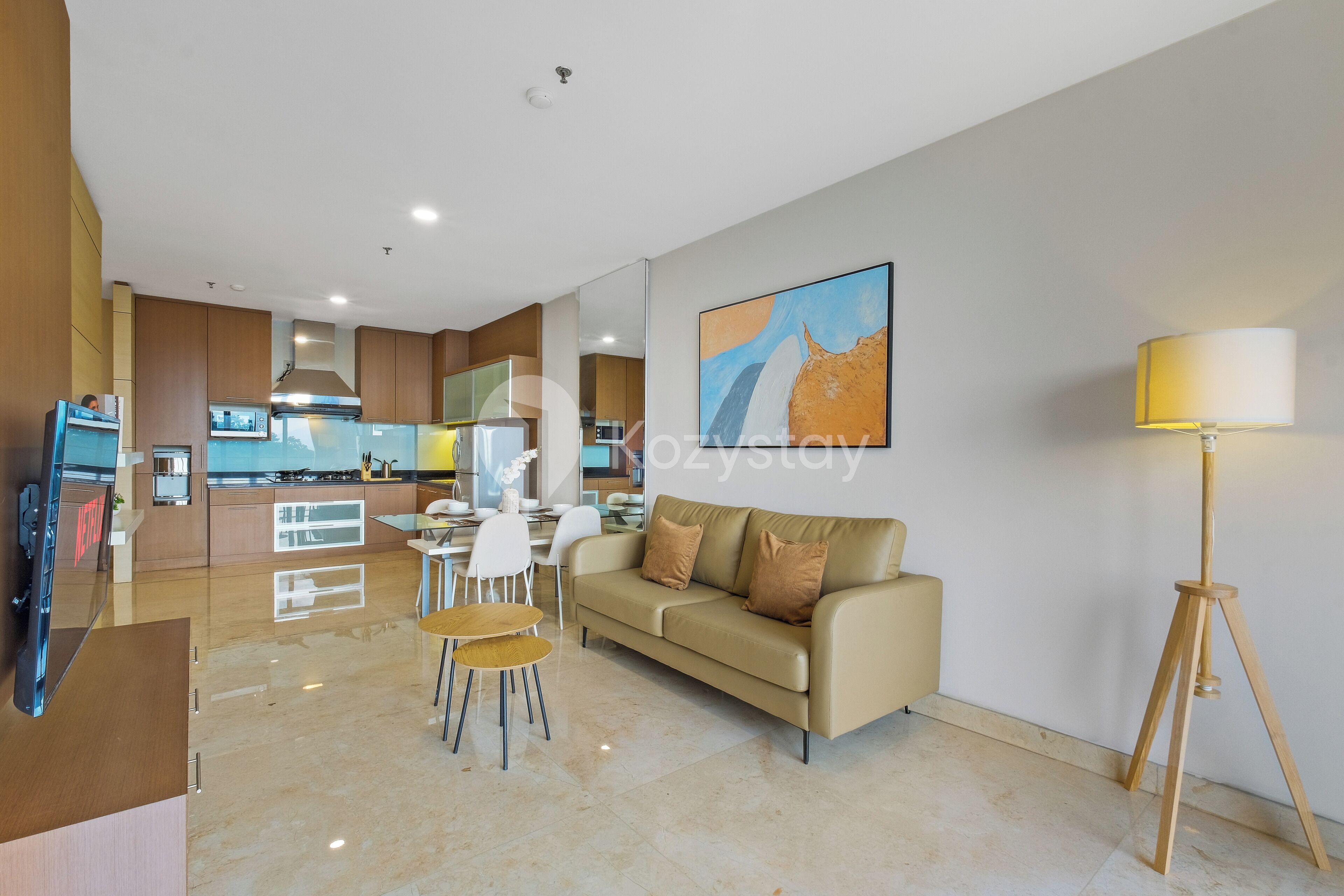 A modern living room with a sofa, chairs, and a dining table.