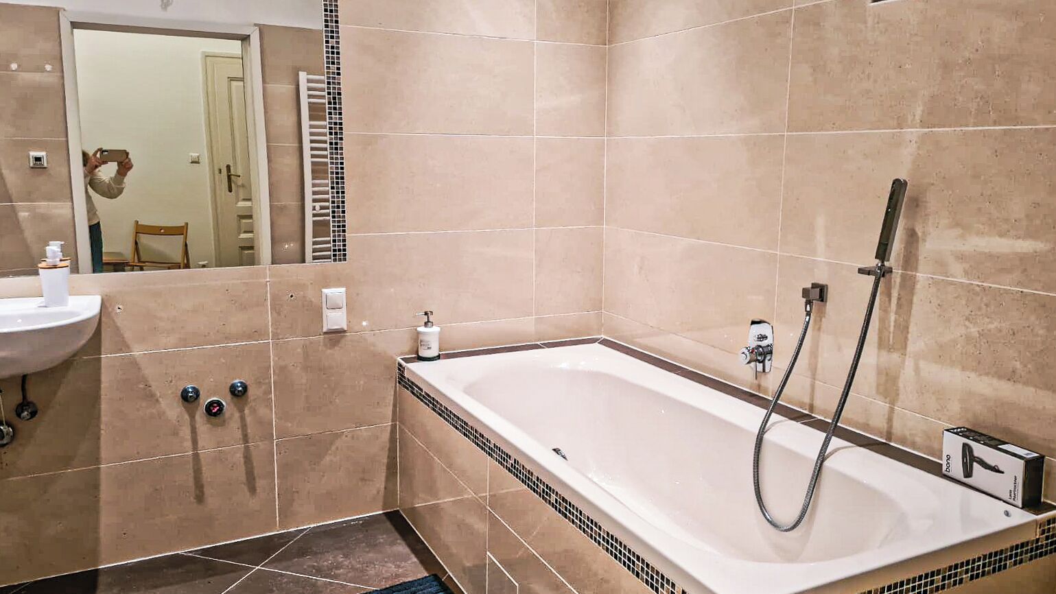 Ein modernes Badezimmer mit einer großen Badewanne, einem Waschbecken und einem Spiegel.