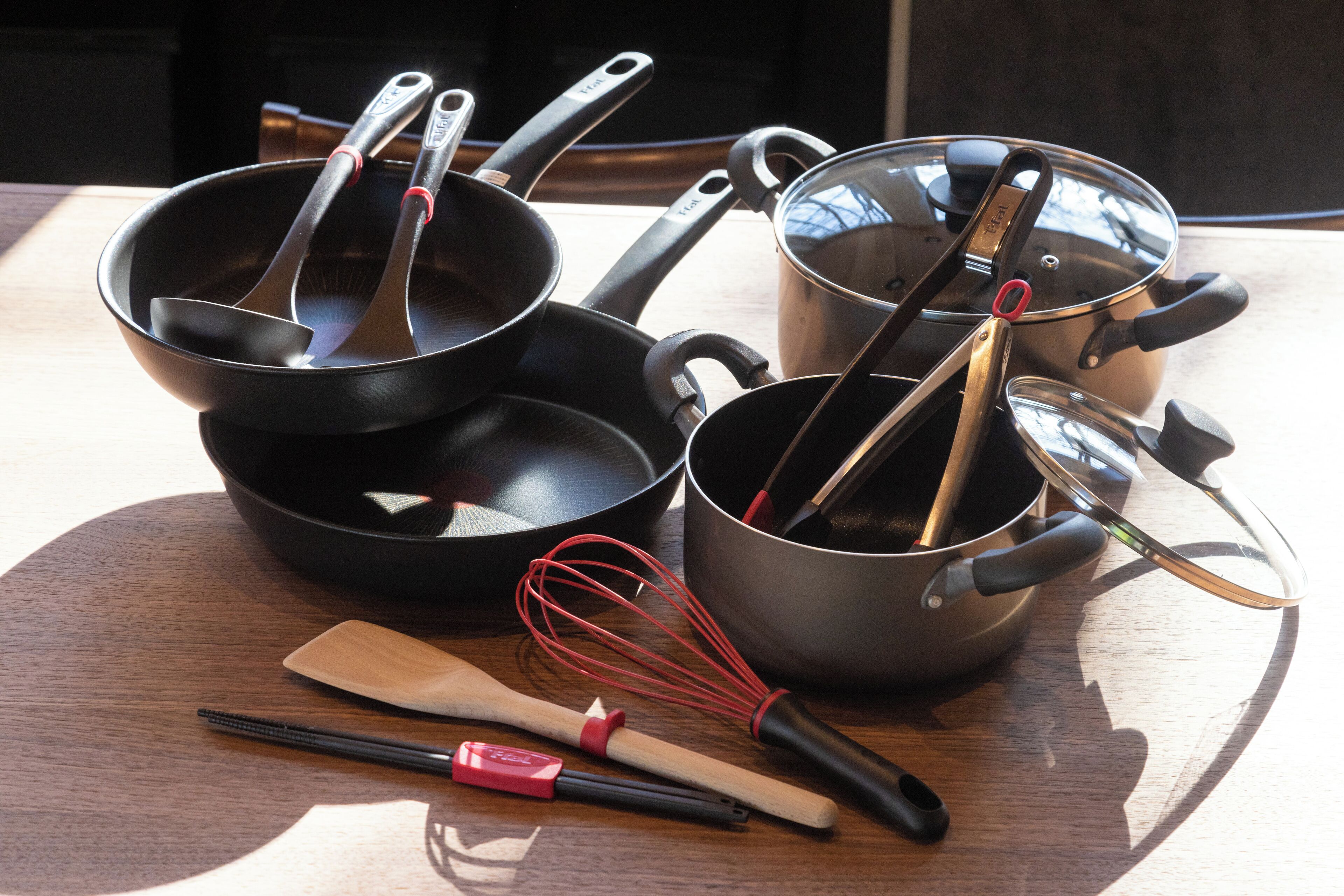 A kitchen counter with various cooking utensils and pots.