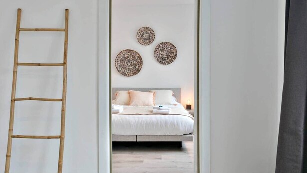 A bedroom with a bed, a ladder, and three wall decorations. - Spacious townhouse in the centre of Knokke (Knokke-Heist)