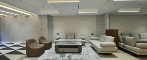 A modern lounge area with a sofa, armchairs, and a coffee table. - Twenty Three Urban Suites (Hyderabad)