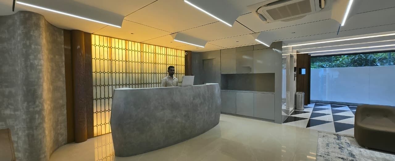 A modern reception area with a curved desk, a patterned wall, and a checkered floor.