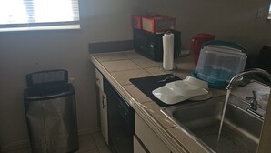 A compact kitchen with a sink, a dish rack, and a trash bin. - Charming 1-bedroom apartment in serene Elyria with AC (Elyria)