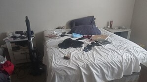 A cluttered bedroom with a bed, a desk, and a vacuum cleaner. - Charming 1-bedroom apartment in serene Elyria with AC (Elyria)