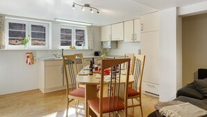 A compact kitchen with a dining area, a microwave, and a window with curtains. - Apartment 'Alte Schmiede 2 Apartments' with Mountain View, Private Terrace and Wi-Fi (Feldberg (Schwarzwald))