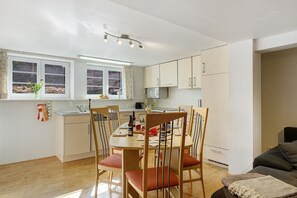 A compact kitchen with a dining area, a microwave, and a window with curtains. - Apartment 'Alte Schmiede 2 Apartments' with Mountain View, Private Terrace and Wi-Fi (Feldberg (Schwarzwald))