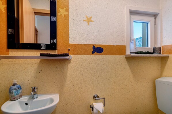A bathroom with a sink, mirror, and window.