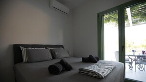 A bedroom with a bed, pillows, and a neatly made bedspread. - Newly built detached house, private pool, sea views, Aegina, 400m from the beach (Aegina Agioi)
