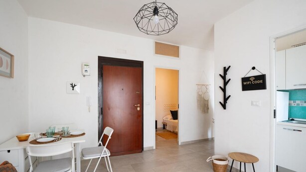 A modern interior with a dining area, a kitchen, and a living space. - Porto Marina by Rentbeat (Villanova di Ostuni)