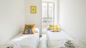 A room with two beds, a balcony, and a yellow picture frame. - Porto Marina by Rentbeat (Villanova di Ostuni)