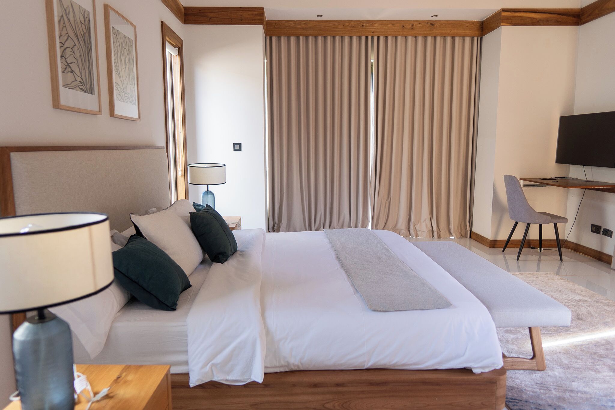 Een moderne hotelkamer met een groot bed, een bureau, een stoel en een televisie.
