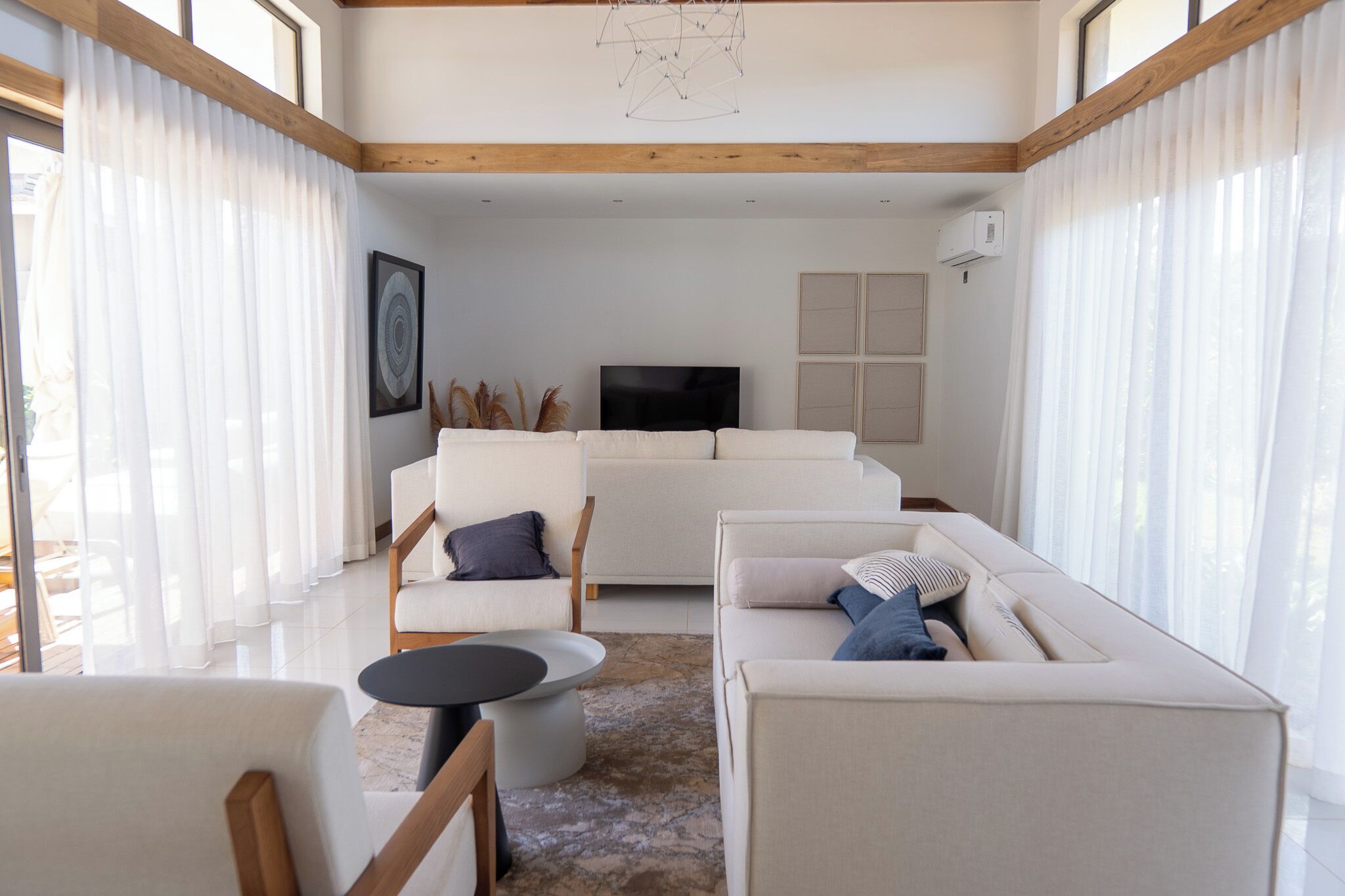 Una sala de estar moderna con un conjunto de sofá, un televisor y una mesa de centro.