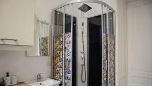 A bathroom with a shower enclosure, a sink, and a mirror. - Comfort 2BR Apt Long Stay Friendly (Vienna)