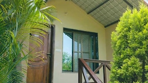 A building with a wooden staircase leading to a door, surrounded by greenery. - The Palash Vann Resort (Kurai)