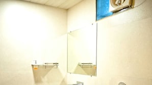 A bathroom with a white sink, a mirror, a toilet, and a cabinet. - The Palash Vann Resort (Kurai)