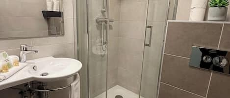Ein modernes Badezimmer mit einer Duschkabine, einem Waschbecken und einer Toilette.
