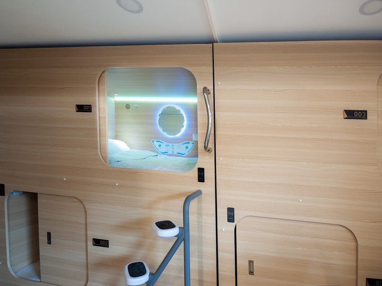 A room with a wooden interior, a circular window with a light, and a small exercise area with a step and a bench.