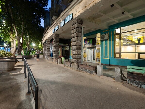 A building with a sign reading "Happy Lounge" and a large window displaying various items. - Capsule Hotel Happy lounge (Tbilisi)