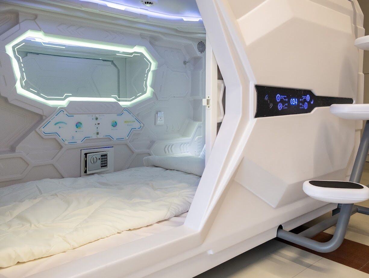 A medical imaging room with a bed, control panel, and a digital display.