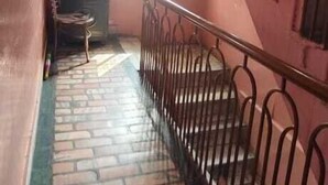 A staircase with metal railings leading to an upper floor. A window with metal bars is visible on the wall. - Hotel Sita Kunwar (Prayagraj)
