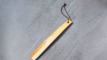 A wooden tag with a string on a grey textured surface.