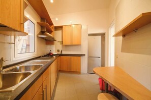 A kitchen with wooden cabinets, stainless steel sinks, and a built-in oven.