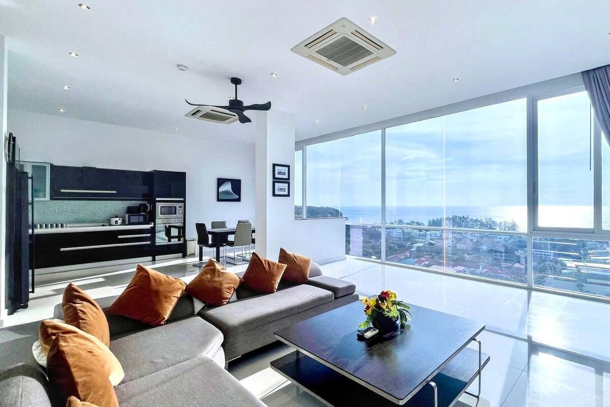 Ein modernes Wohnzimmer mit Sofa, Couchtisch und Blick auf die Stadt.