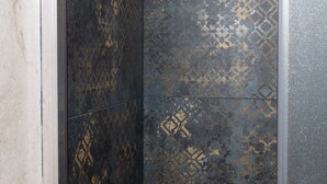 A close-up of a textured wall with geometric patterns and a reflective surface. - Malva Rooms (Agrigento)