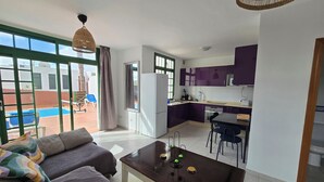 Uma sala de estar moderna com um sofá, uma mesa de centro e vista para uma piscina.