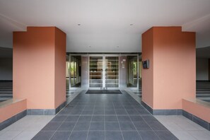 A spacious lobby with a tiled floor, glass doors, and orange walls. - Diletta - Big Family Apartment (Bari)