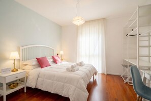 Une chambre à coucher bien rangée, avec un lit, des lampes de chevet, une table de chevet, une chaise et une armoire.